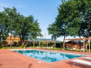 a large swimming pool in a yard with trees at Scenic Apartment Near Pian di Sco with Private Terrace in Pian di Scò