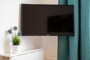 a flat screen tv hanging on a wall at Hotel Clement - Bed & Breakfast in Ingelheim am Rhein