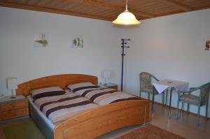 Bett in einem Zimmer mit 2 Stühlen und einem Tisch in der Unterkunft Gästehaus Haller in Bodenmais