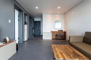 a living room with a couch and a table at Aewol Stay in Jeju Hotel&Resort in Jeju