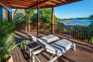 une terrasse avec deux chaises longues et une vue sur l'eau dans l'établissement Casuarina 18 Ocean View House Central Location BBQ Golf Buggy, à Île Hamilton