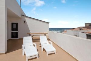 balcone con sedie bianche, tavolo e oceano di Apartamento Abuelo Miguel a Cotillo