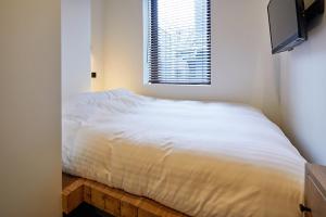 a white bed in a bedroom with a window at mizuka Imaizumi 4 - unmanned hotel - in Fukuoka
