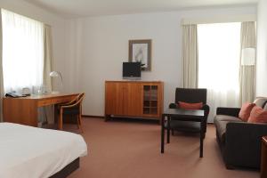 a hotel room with a bed and a desk at Schloss Hohenkammer in Hohenkammer