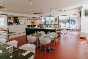 um restaurante com cadeiras e mesas brancas e um bar em ibis Newcastle em Newcastle