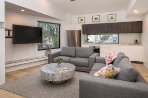 uma sala de estar com dois sofás e uma televisão em Central Heights - Main Street Views em Margaret River