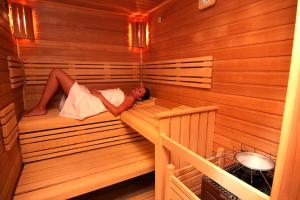 a man is laying in a sauna at Retro Riverside Wellness Resort in Karlovy Vary