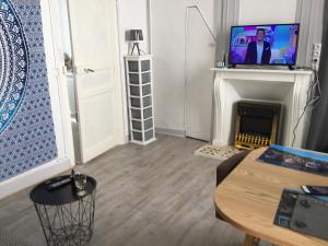 un salon avec une télévision et une cheminée dans l'établissement Avec un minimum de 3 nuits Studio 80 m de la mer et 300 m des commerces, au Tréport 11 autres photos