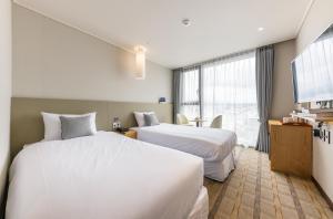 Postel nebo postele na pokoji v ubytování Shin Shin Hotel Cheonjiyeon