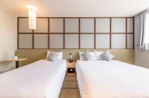 Postel nebo postele na pokoji v ubytování Shin Shin Hotel Cheonjiyeon