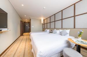 Postel nebo postele na pokoji v ubytování Shin Shin Hotel Cheonjiyeon