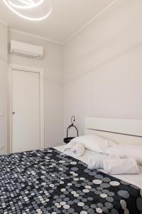a bedroom with a bed with a black and white rug at Appartamento Birba e Sgrinfia in Lido di Ostia