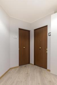 two doors in an empty room with wooden floors at Appartamento Birba e Sgrinfia in Lido di Ostia