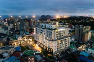 a large white building in a city at night at Shin Shin Hotel Cheonjiyeon in Seogwipo