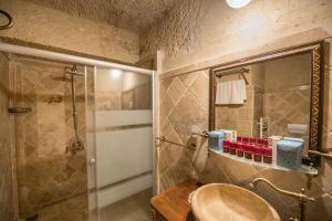 y baño con lavabo y ducha con espejo. en Charming Cave Hotel, en Göreme