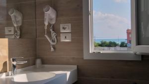 bagno con lavandino e finestra di HOTELRISTORANTE IL PUNTO a Marotta