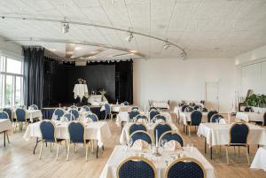 een feestzaal met witte tafels en blauwe stoelen bij Hotel Limfjorden in Thisted