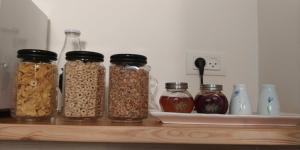 a shelf with four jars of nuts and seeds at The House By The Mulberry Tree in Neve Ilan