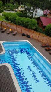 a large blue swimming pool with chairs and a fence at Park-Hotel Chusovaya in Sloboda