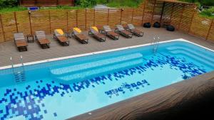 a swimming pool with a bunch of chairs next to it at Park-Hotel Chusovaya in Sloboda