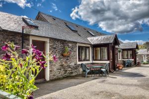 a stone cottage with a table and chairs in front of it at Winkston Holiday Accommodation Peebles in Peebles