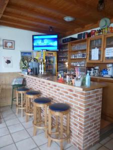 un bar en un restaurante con taburetes en Camping Pommiers des Trois Pays, en Licques