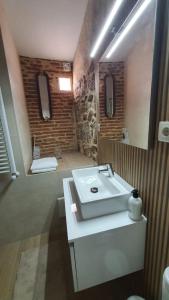 Un baño con un lavabo blanco y un espejo. en Casas del Castillo, 3, en Ávila