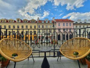 dos sillas y una mesa frente a una valla en SleepWell Boutique Apartments, en Varsovia