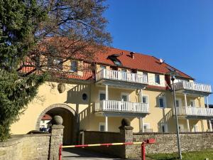 ein großes gelbes Gebäude mit rotem Dach in der Unterkunft Apartment Torhaus Schloss Wocklum in Balve