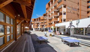 une rue urbaine vide avec bancs et bâtiments dans l'établissement Résidence Pierre & Vacances Aconit, aux Menuires