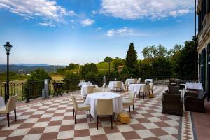 a restaurant with white tables and chairs on a checkered floor at Hotel Villa La Bollina in Serravalle Scrivia +147 photos