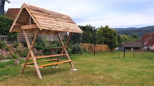 einer Holzkonstruktion mit einem Dach auf einem Hof in der Unterkunft Kaline 1 in Wildflecken