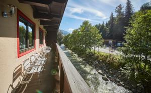 balkon budynku z krzesłami i rzeką w obiekcie Appartement Riverside w Saalbach Hinterglemm