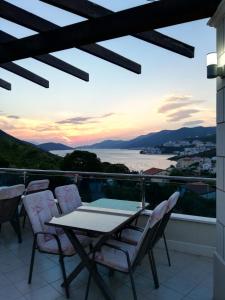 a table and chairs on a balcony with a view of the ocean at Hotel Orka in Neum