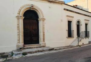 LizzanelloにあるIl Giardino Segretoの白い建物の裏側の黒い扉