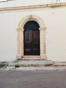 LizzanelloにあるIl Giardino Segretoの白い建物の大きな木製の扉