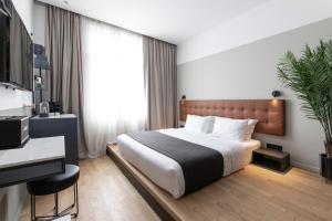 a hotel room with a bed and a desk at The Modernist Thessaloniki in Thessaloniki