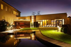 a house with a pond in front of it at Best Western Premier Park Hotel & Spa in Bad Lippspringe