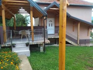 una casa con una terraza con una mesa. en Apartman Vesna, en Višegrad