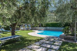 uma piscina num quintal com um banco e árvores em appartamento casa stefi n1 em Malcesine