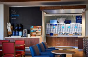 エンタープライズにあるHoliday Inn Express & Suites - Enterprise, an IHG Hotelの青い椅子とテーブルのあるコーヒーショップ