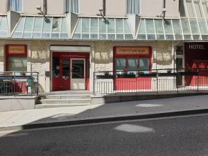 un edificio con una puerta roja y un hotel en Hôtel Hermance en Bellegarde-sur-Valserine