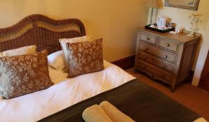 a bedroom with a bed and a wooden dresser at Kearsney Manor in KwaDukuza