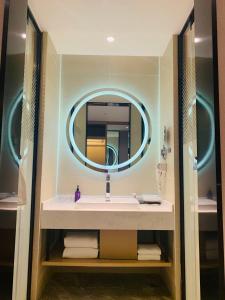 W łazience znajduje się umywalka i lustro. w obiekcie Mercure Shanghai Hongqiao Railway Station w Szanghaju