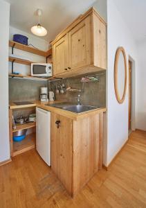 eine Küche mit Holzschränken und einem Waschbecken in der Unterkunft Appartement Schattberg in Saalbach-Hinterglemm