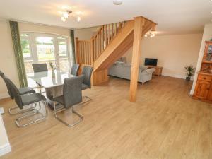 a living room with a table and chairs and a couch at Woodpecker Barn in Pontyclun