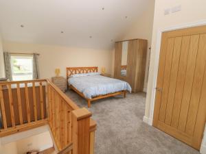 1 dormitorio con 1 cama y puerta de madera en Nuthatch Barn, en Pontyclun