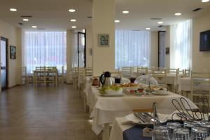 un comedor con mesas con manteles blancos en Hotel Villa Aljor, en Golem