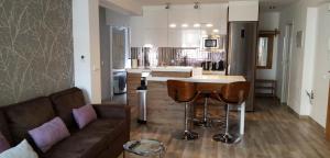 cocina y sala de estar con sofá y bar en Apartament Los Planetas, en Alicante