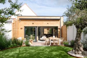 a wooden house with a table in a yard at Fabulous 4 bedrooms villa near Zwin with a garden in Knokke-Heist